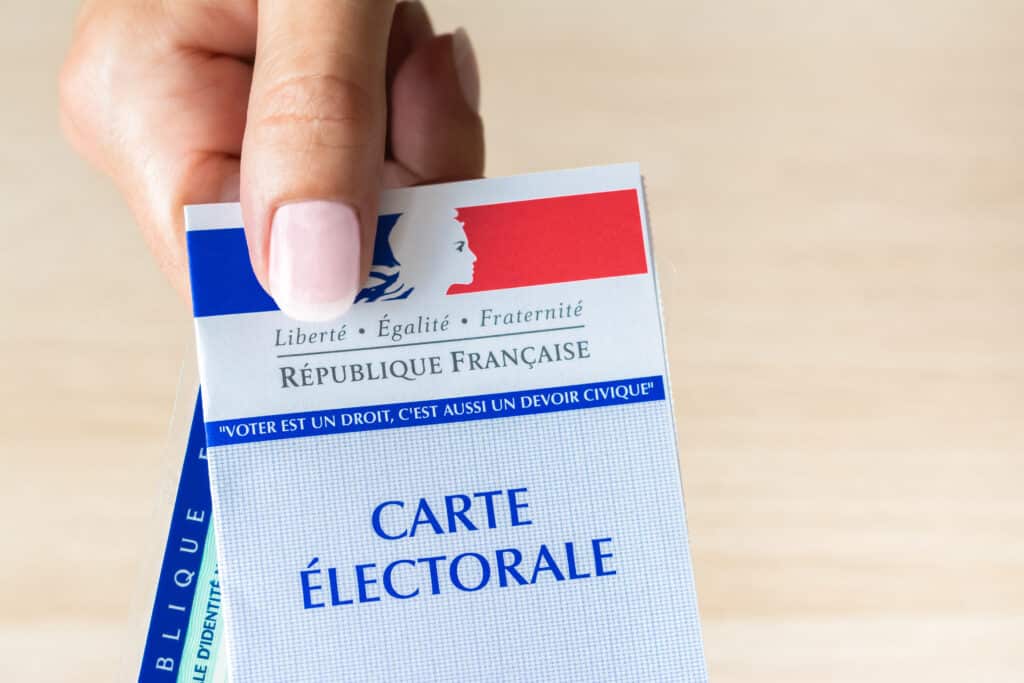 Personne qui montre une carte électorale et une carte d'identité